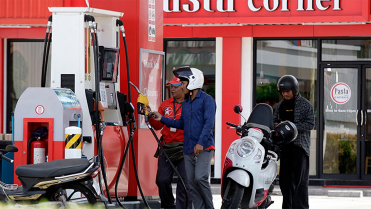 Các tài xế xe máy chờ đổ xăng tại một trạm xăng ở thủ đô Phnom Penh, Campuchia - Ảnh: Khmer Times