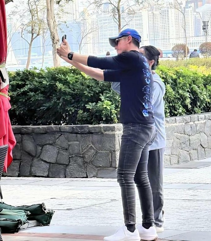 Hoắc Kiến Hoa đứng chụp ảnh với một người qua đường và chiếc quần bó của anh lập tức gây chú ý. Ảnh: Weibo