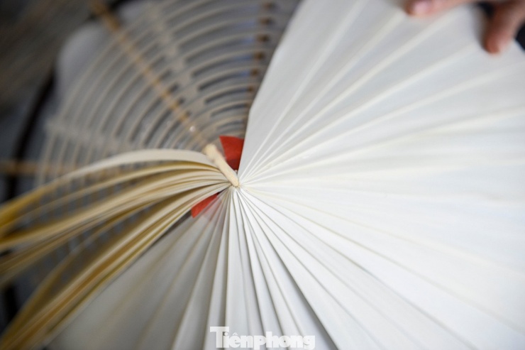 Hiện, cơ sở của bà Toan đang tạo việc làm thường xuyên cho khoảng 50 lao động, với sản lượng trung bình 500 chiếc nón/ngày. Thu nhập của người làm nón dao động từ 120.000 - 150.000 đồng/ngày. Trong ảnh là công đoạn người thợ xếp từng lớp lá, căn chỉnh sao cho đều và kín.