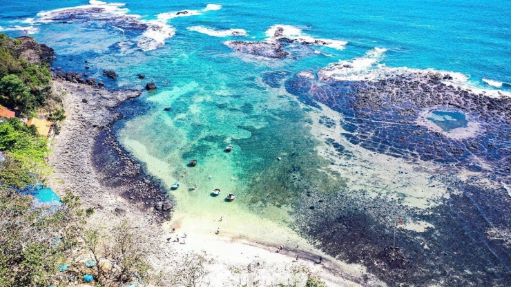 Đường bờ biển uốn cong mềm mại, xen kẽ là những mảng đá đen xếp chồng, dấu tích của những dòng nham thạch từng phun trào từ hàng triệu năm trước.