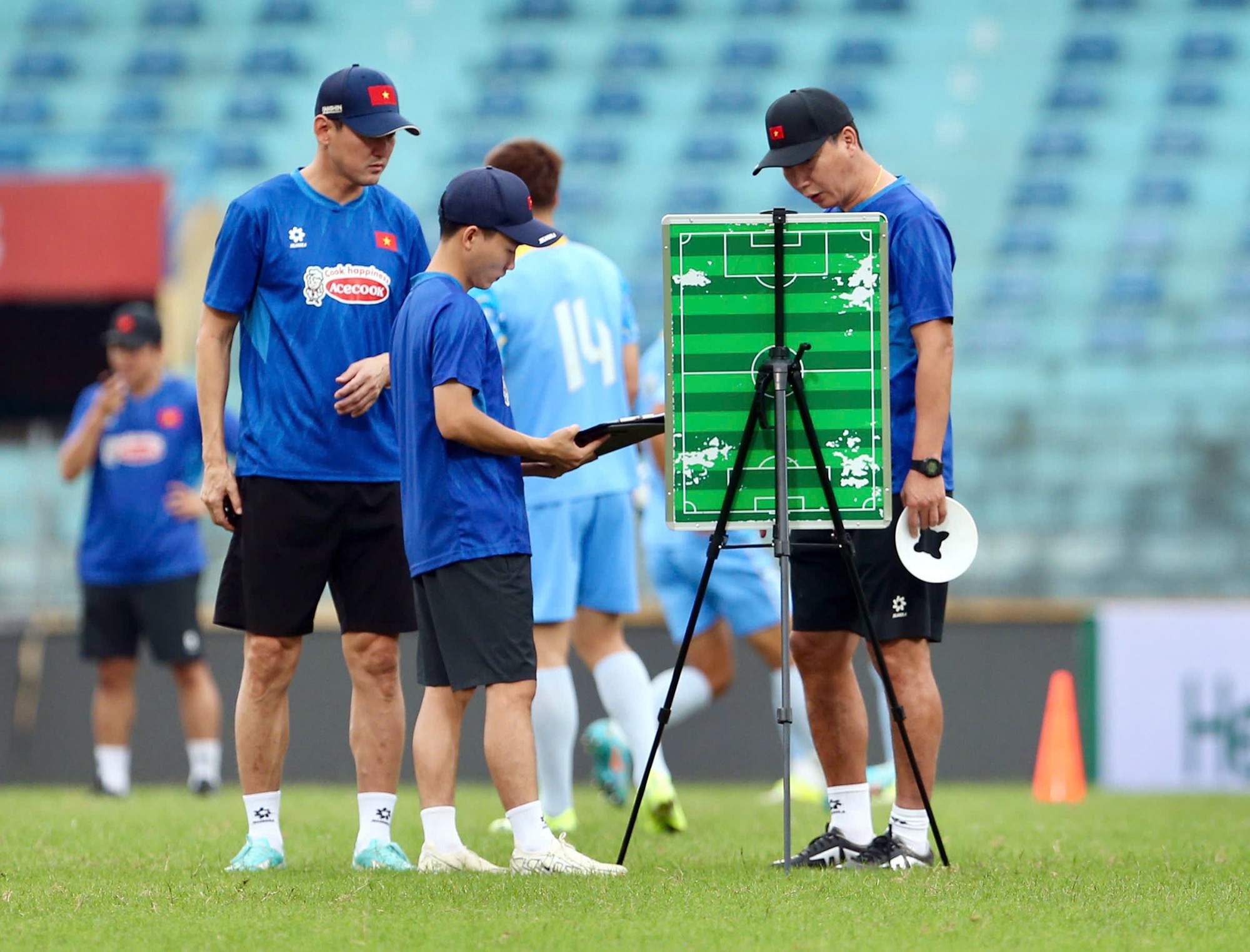 HLV Kim Sang Sik bàn chiến thuật cùng các trợ lý.