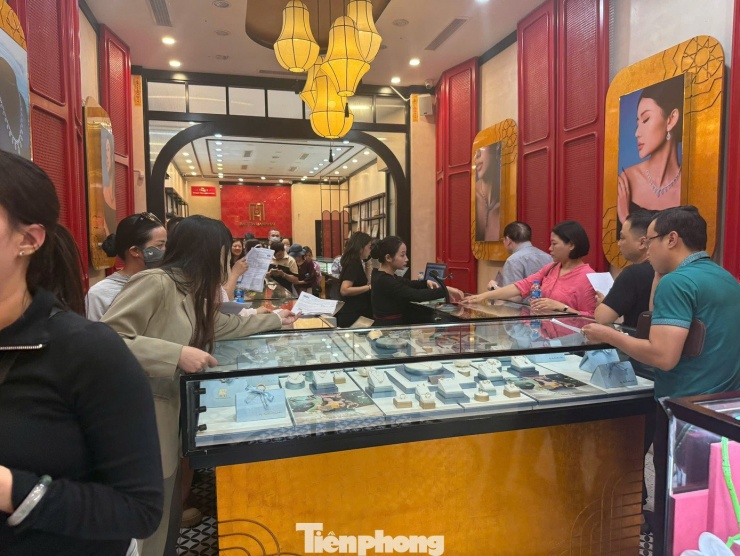 Người dân chờ hàng tiếng đồng hồ xếp hàng từ vỉa hè đến bên trong cửa hàng Bảo Tín Mạnh Hải để lấy vàng.