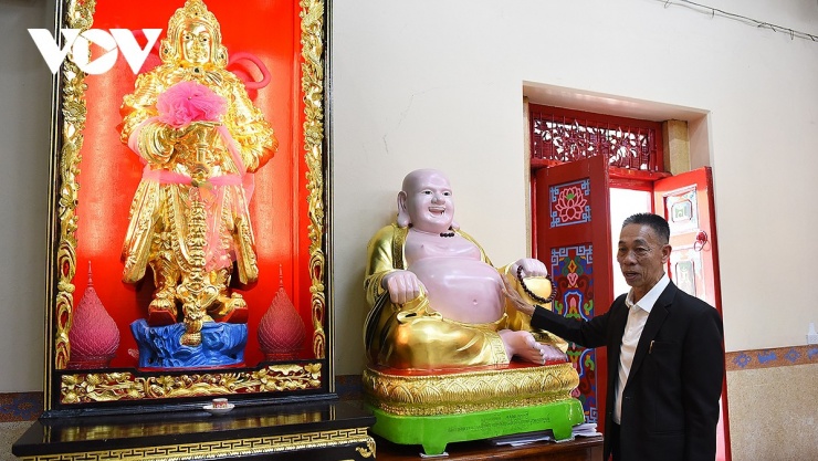 Ông Trần, một người dân địa phương giới thiệu bức tượng Di Lặc với tạo hình trong Phật giáo Việt Nam.