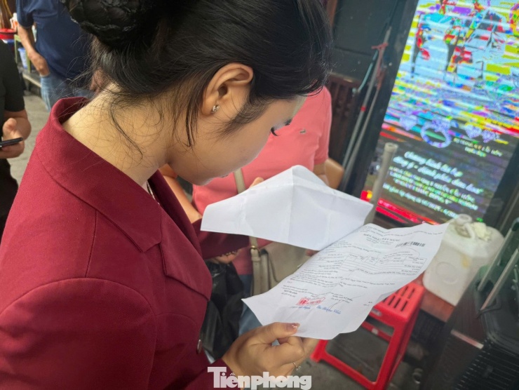 Nhân viên kiểm tra giấy hẹn trả vàng đúng ngày của khách.