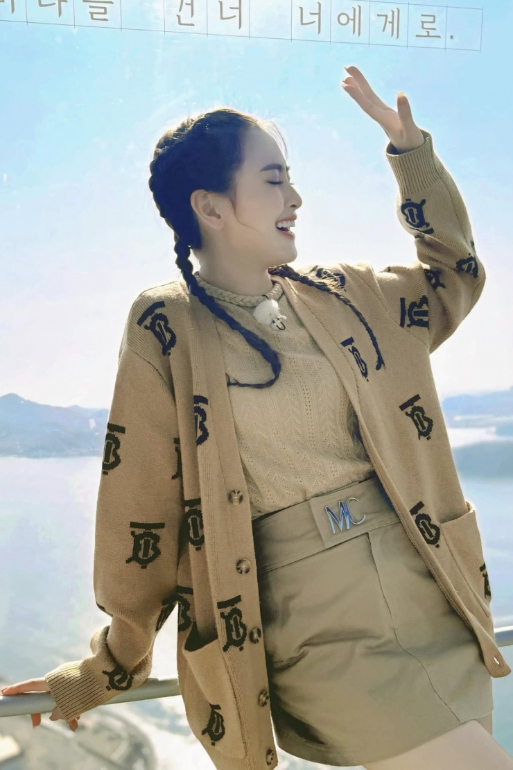 MC phối cardigan với áo len, chân váy ngắn đồng điệu màu sắc trong chuyến du lịch nước ngoài.