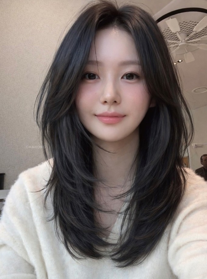 Kiểu tóc dài uốn sóng lơi dùng các lọn tóc làm mờ đường viền hàm, giúp khuôn mặt vuông trông mềm mại hơn. Ảnh: Instagram chahong_official