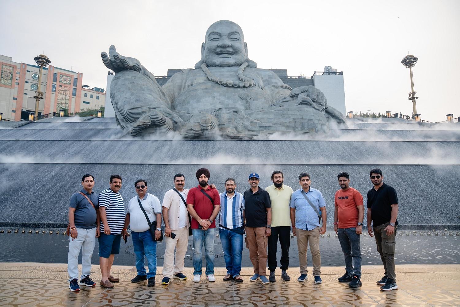 Đoàn du khách Ấn Độ chụp ảnh kỷ niệm dưới chân Tượng Bồ Tát Di Lặc.