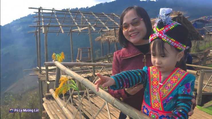 Em nhỏ trong trang phục dân tộc lên chụp ảnh mây cùng mẹ