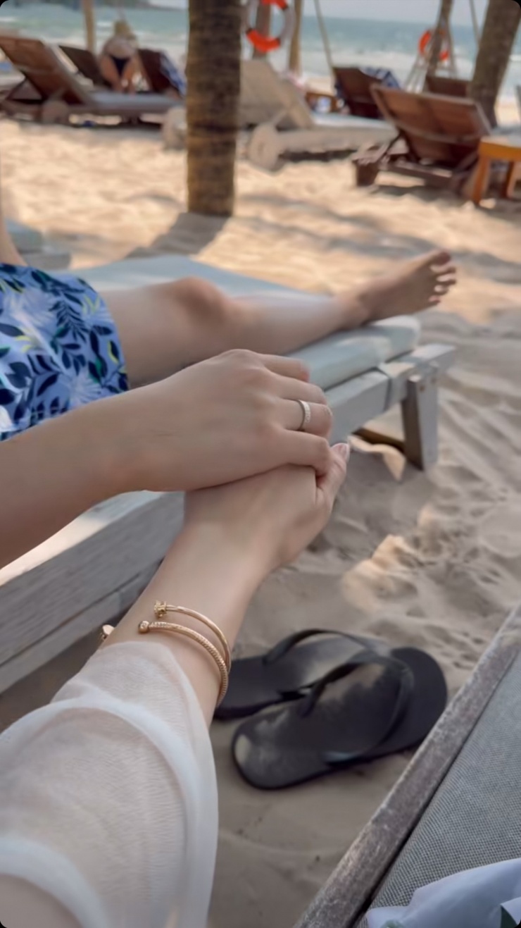 Hoa hậu đăng ảnh nắm tay ông xã khi tắm biển, đồng thời đeo vòng tay Possession dạng hở bằng vàng hồng 18K, nạm kim cương của Piaget.