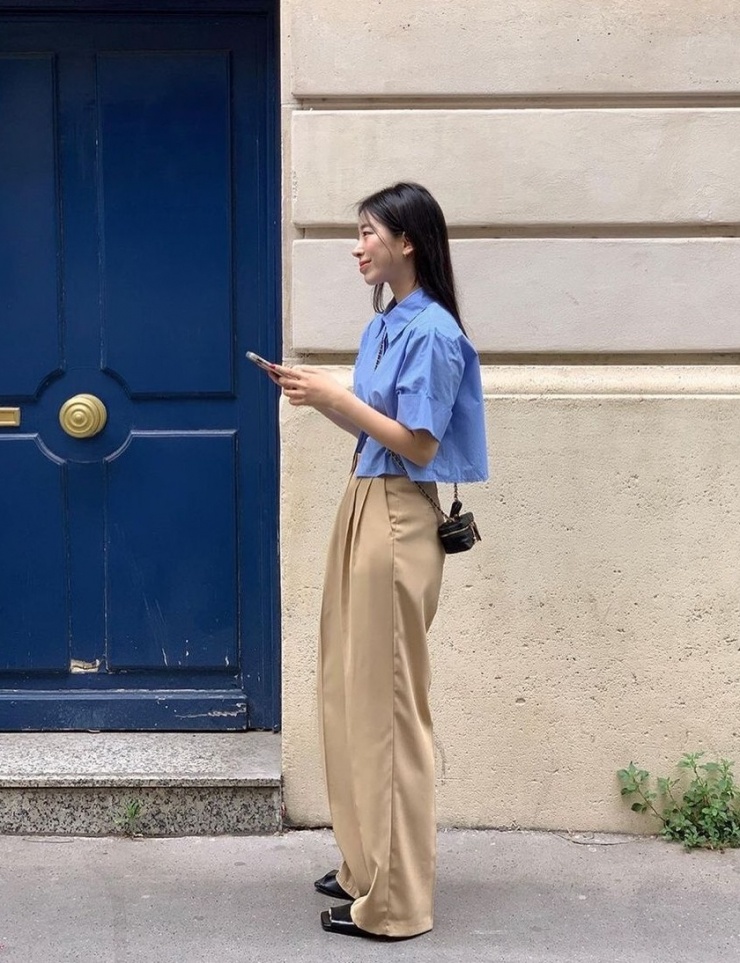 Những cô gái theo đuổi phong cách tối giản có thể chọn sơ mi dáng ngắn, quần vải dáng baggy, giày loafer, nhấn bằng túi mini.