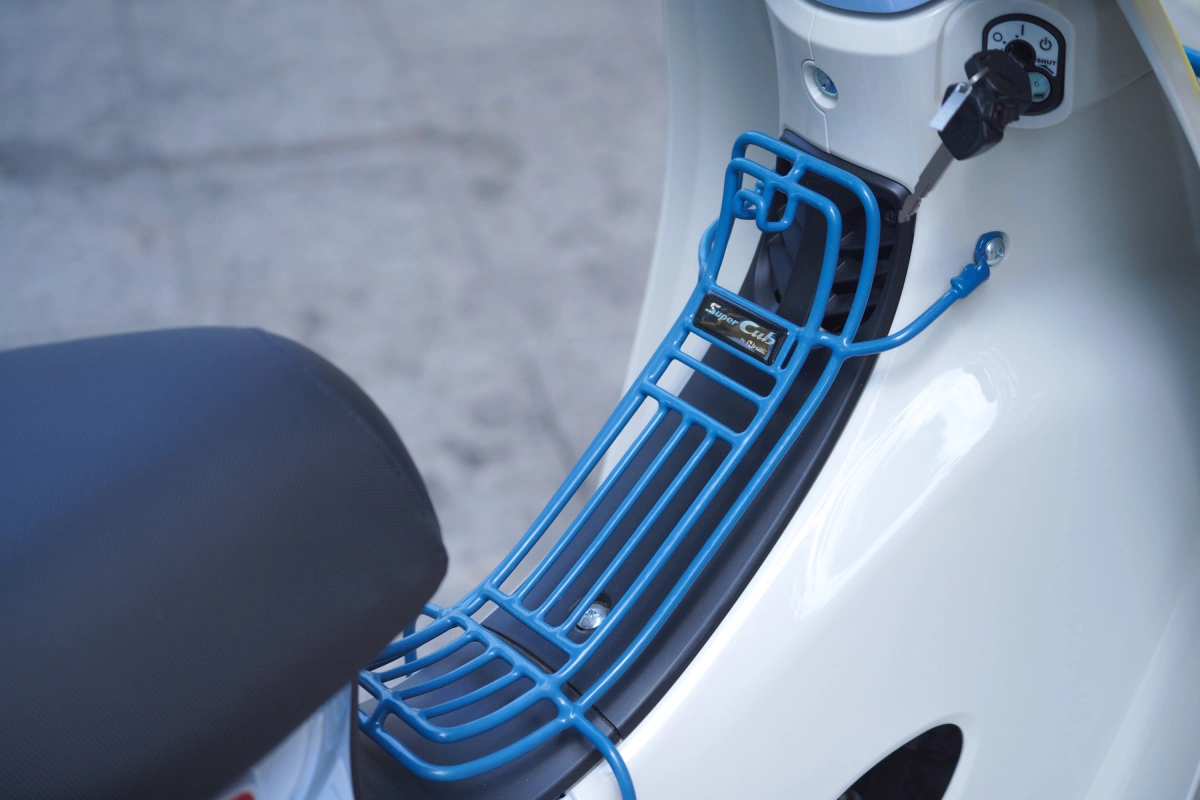 Xe đi kèm bộ phụ kiện gồm giá để đồ trước yên và trên vè chắn bùn bánh trước. Cả hai đều mang màu xanh đậm hơn so với thân xe.