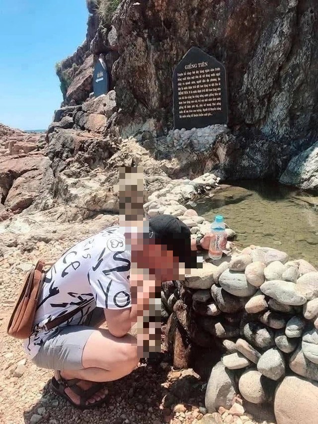 Một du khách lấy nước tại Giếng Tiên để uống với hy vọng gặp nhiều may mắn