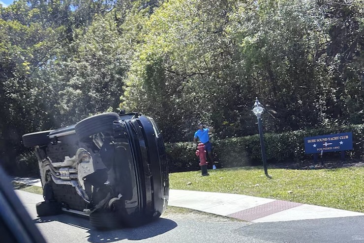 Tiger Woods đứng cạnh chiếc xe bị lật của mình ở Jupiter Island, Florida.