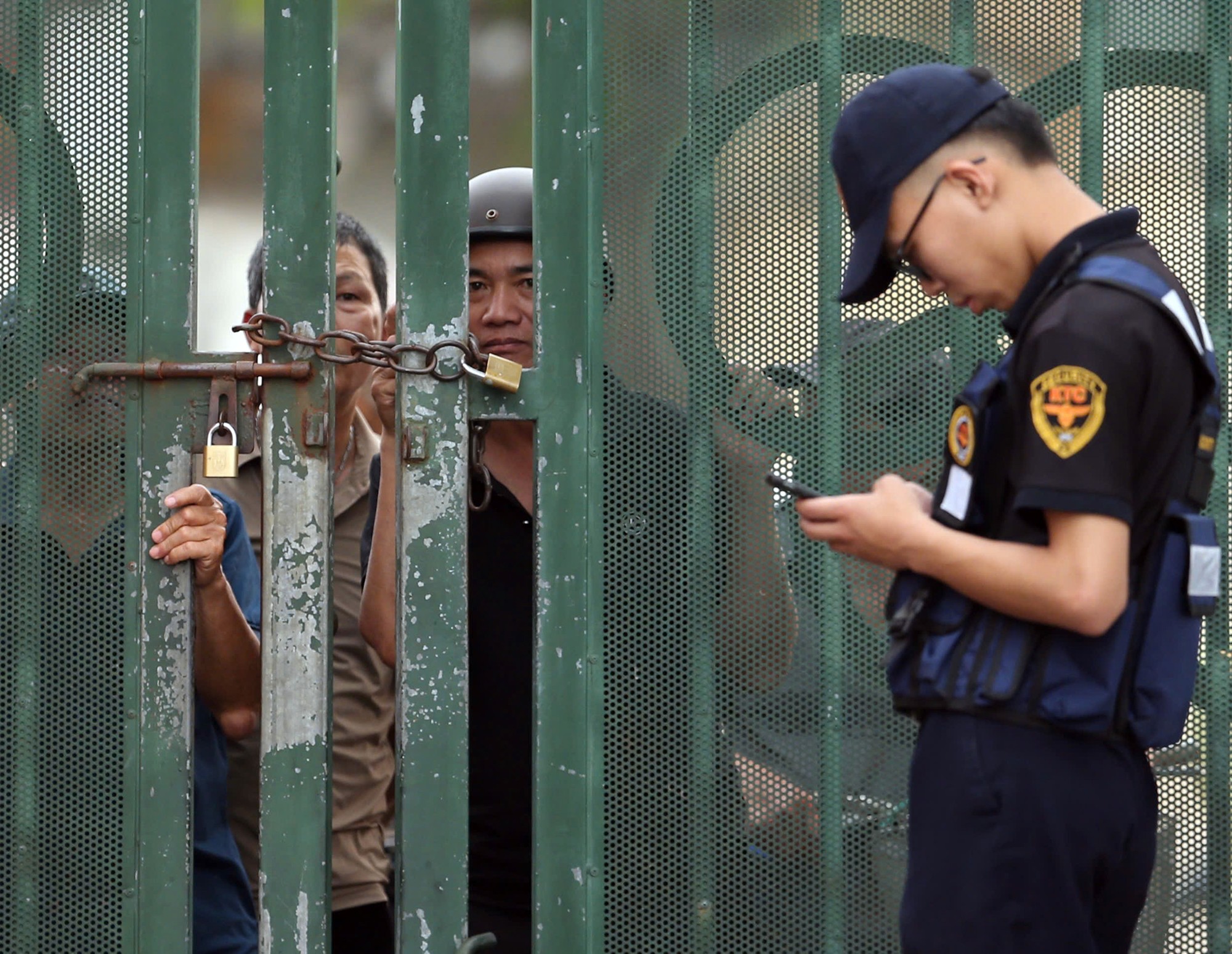 Nhiều cổ động viên Ninh Bình tò mò theo dõi buổi tập của ĐT Việt Nam qua khe cổng sân Thiên Trường.