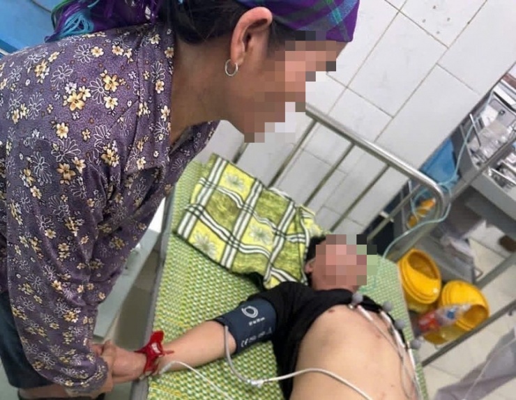 Đại úy Vũ Viết Bằng cùng người dân đưa hai vợ chồng anh C.S.L đến cơ sở y tế sơ cứu. Ảnh: Cơ quan Công an.