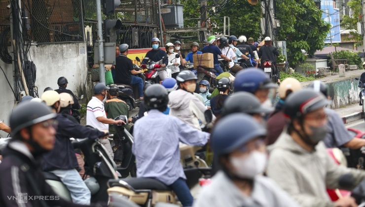 Người dân từ những con ngõ nhỏ tìm cách di chuyển vào đường lớn để nhập vào dòng người di chuyển qua cầu. Một số thấy tắc chọn phương án leo lên hè đường, bờ kè đê.