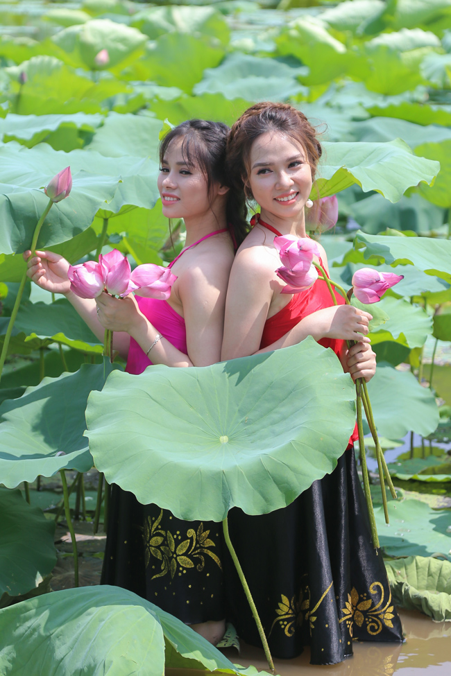Trong trang phục áo yếm và váy đụp, bờ vai mỏng manh và làn da trắng mịn màng của thiếu nữ được khoe trọn, làm toát lên vẻ đẹp chân quê mà gợi cảm của người phụ nữ Việt Nam.