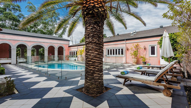 Ngôi nhà nhà màu hồng này mang phong cách của một khu nghỉ mát với bể bơi, cây xanh, giường tắm nắng…