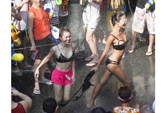 Du khách đổ về Thái Lan dịp này cũng ăn mặc phóng khoáng khi tham dự lễ hội té nước.