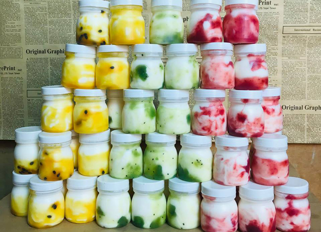 Chị cho biết sữa chua hoa quả có 4 vị: việt quất, chanh dây, kiwi, dâu tây. Tất cả đều có giá 5.000 đồng/hộp. Giá khá rẻ nên khách thường đặt mua hàng chục hộp về ăn dần.