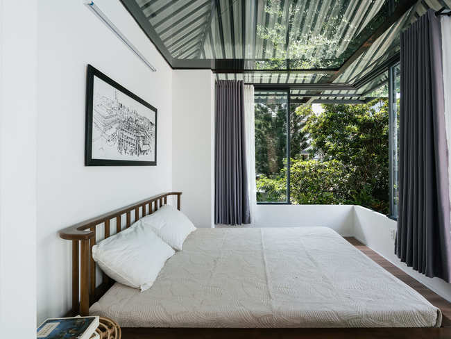 Phòng ngủ trang bị cửa kính lớn giúp đón ánh sáng tự nhiên và không khí mát mẻ từ bên ngoài