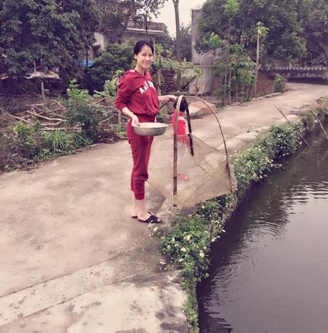 Còn đây là Thái Hà, cô ăn mặc giản dị, đi dép lê, cất vó bắt cá ở quê.