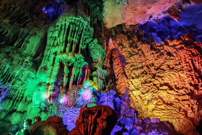 Các vách hang bao gồm các nhũ đá và măng đá được chiếu ánh sáng đèn màu lung linh.