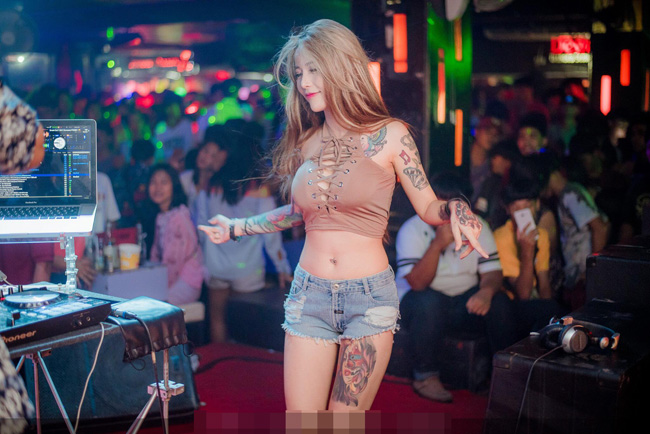 Cánh tay và bắp đùi của DJ Katoy xăm hình gương mặt 2 cô gái. 