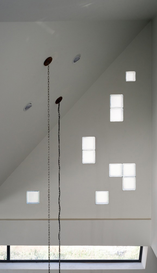 Những ô kính ngẫu hứng trên bức tường phòng khách vừa giúp lấy sáng vừa như một cách trang trí đơn giản nhưng mang lại hiệu quả cao.