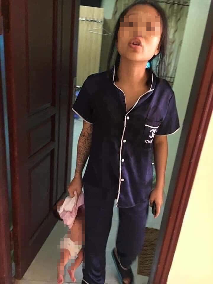 Lộ diện người mẹ trẻ xách con &#34;lủng lẳng&#34; trên tay gây sốc - 1
