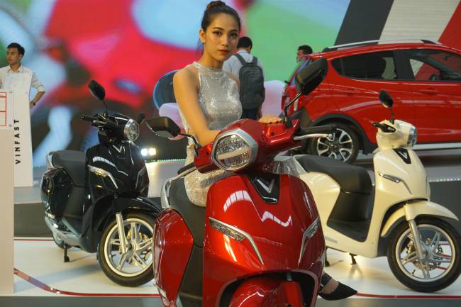 Người đẹp tạo dáng bên xe tay ga Klara của Vinfast tại Vietnam Auto Expo 2019 đang diễn ra ở Hà Nội.