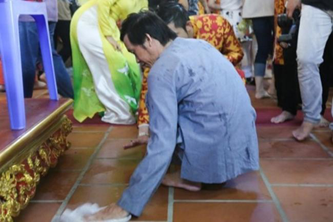 Anh còn tự tay dùng giẻ lau sàn nhà để tránh trơn trượt cho khách tới thăm nhà thờ tổ.
