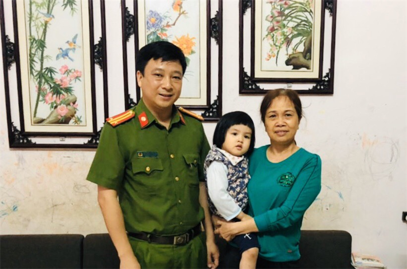 Trung tá Trương Thụy Hải chụp ảnh lưu niệm với gia đình cháu bé