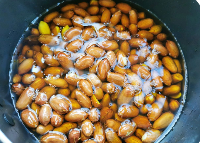  Lạc rửa sạch, ngâm trong nước lạnh có thêm một chút muối. Ngâm khoảng 10 phút sau đó vớt ra để ráo nước. Ngoài ra, việc ngâm này sẽ giúp lạc khi chiên có hương vị ngon và giòn hơn hẳn.