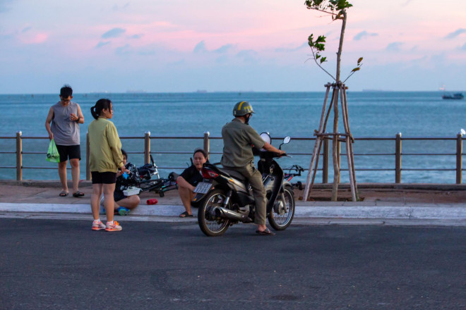 Nhóm bạn trẻ không đeo khẩu trang còn vô tư ngồi nghỉ từng nhóm trên vỉa hè