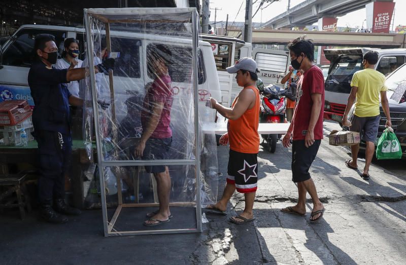 Kiểm tra thân nhiệt người vào một khu chợ ở thủ đô Manila, Philippines.