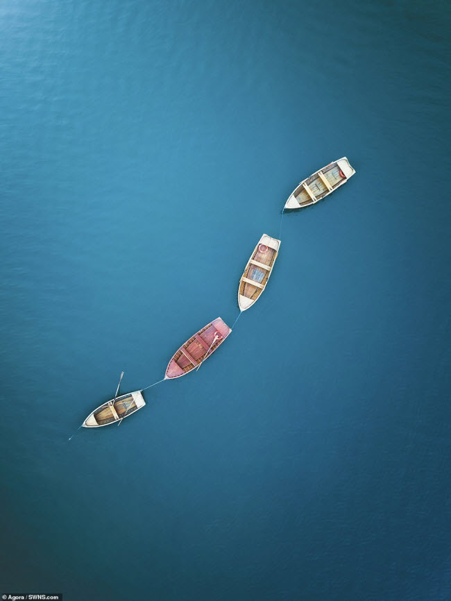 Những chiếc thuyền đậu trên mặt nước phẳng lặng ở Italia.
