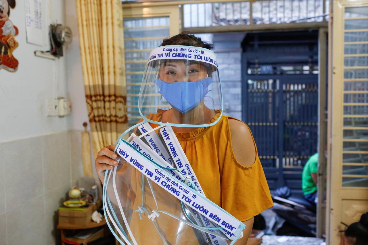 Bà Quach My Linh và những chiếc mặt nạ chống giọt bắn phòng dịch Covid-19 do nhóm của bà tự sản xuất. Ảnh: Yen Duong/Reuters