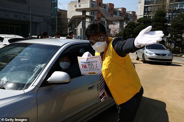 Nhân viên nhà thờ ở Hàn Quốc chỉ dẫn cho người lái xe đến cầu nguyện trong quãng thời gian xảy ra dịch Covid-19.