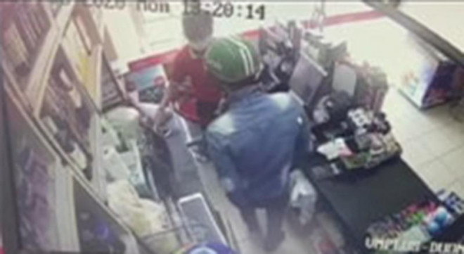 Tên cướp đội mũ bảo hiểm xông vào siêu thị cướp tiền. Ảnh: Cắt từ clip