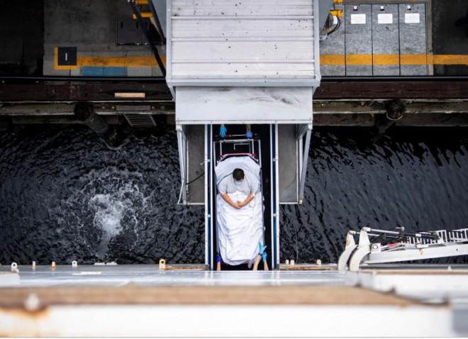 Di chuyển một bệnh nhân không nhiễm COVID-19 lên tàu BV USNS Mercy đậu ở quận Los Angeles, bang California (Mỹ) ngày 8-4. Nhiệm vụ của tàu bệnh viện này là giảm tải cho các bệnh viện trong đất liền, lấy chỗ trống điều trị các bệnh nhân COVID-19. Ảnh: REUTERS