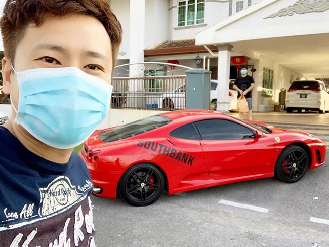 Nhân viên nhà hàng chụp ảnh selfie&nbsp;bên siêu xe màu đỏ khi có đơn hàng khách đặt đưa đến nhà.