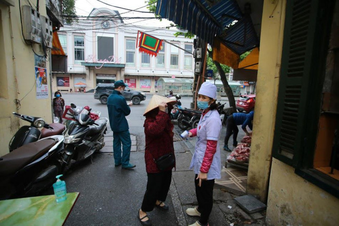 Trước diễn biến phức tạp của dịch COVID-19, UBND phường Hàng Gai tiến hành đặt 3 chốt kiểm soát tại ngõ ra - vào chợ Yên Thái. Mỗi người dân ra vào chợ đều được đo thân nhiệt và sát khuẩn tay.