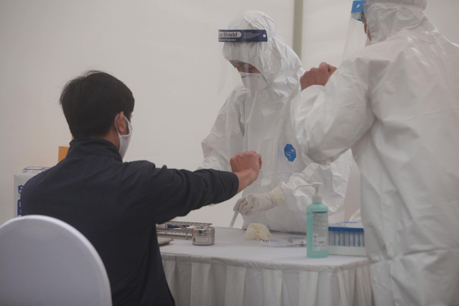 Lực lượng y tế lẫy mẫu xét nghiệm nhanh ngoài cộng đồng tại Trường THCS Đống Đa (Hà Nội). Ảnh: Hồng Phú