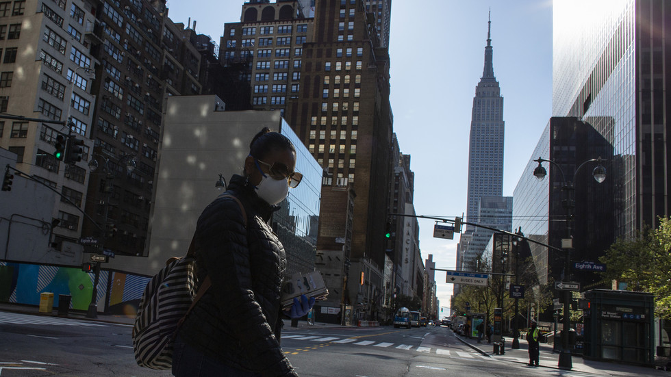 Người phụ nữ đeo khẩu trang đi bộ trên đường phố New York.