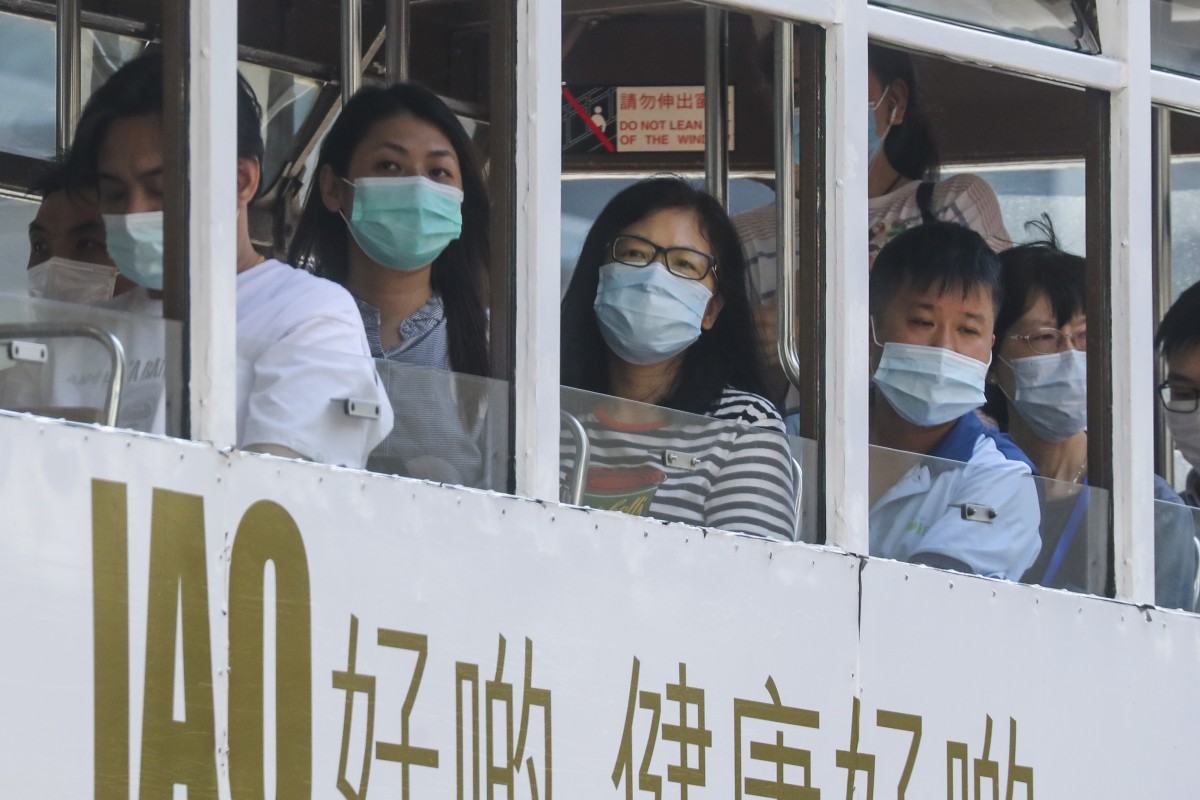 Người Hong Kong đeo khẩu trang trên xe điện.