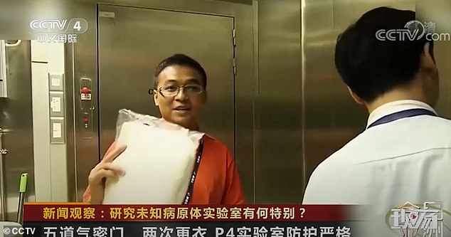 Nhà nghiên cứu Zhang Huajun mô tả cách mặc đồ bảo hộ để vào khu vực phòng thí nghiệm.