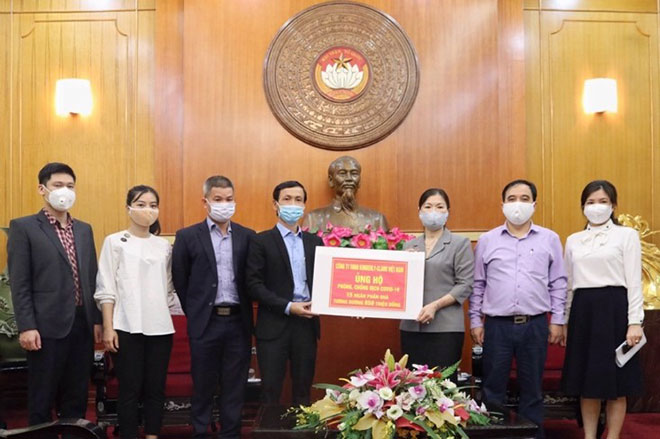 Đại diện của Kotex Việt Nam (đứng bên trái) trao tặng biểu trưng 15,000 phần quà tới đại diện Uỷ ban Mặt trận Hà Nội