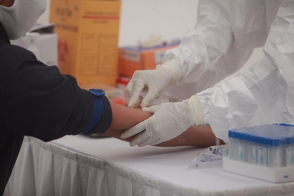 Lực lượng y tế Hà Nội lấy máu xét nghiệm nhanh COVID-19 cho người dân.