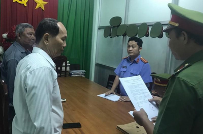 Công an đọc quyết định khởi tố bị can Nguyễn Trí (áo trắng).